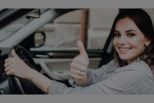 Female driver from Michigan gestures thumbs up after getting her driver's license reinstated.